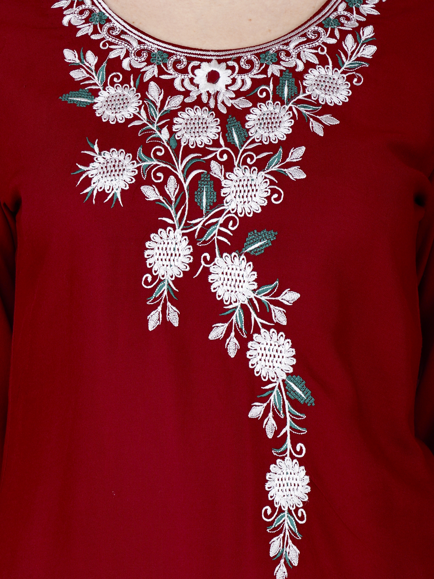 Red short kurti close-up of white floral embroidery with green and teal accents