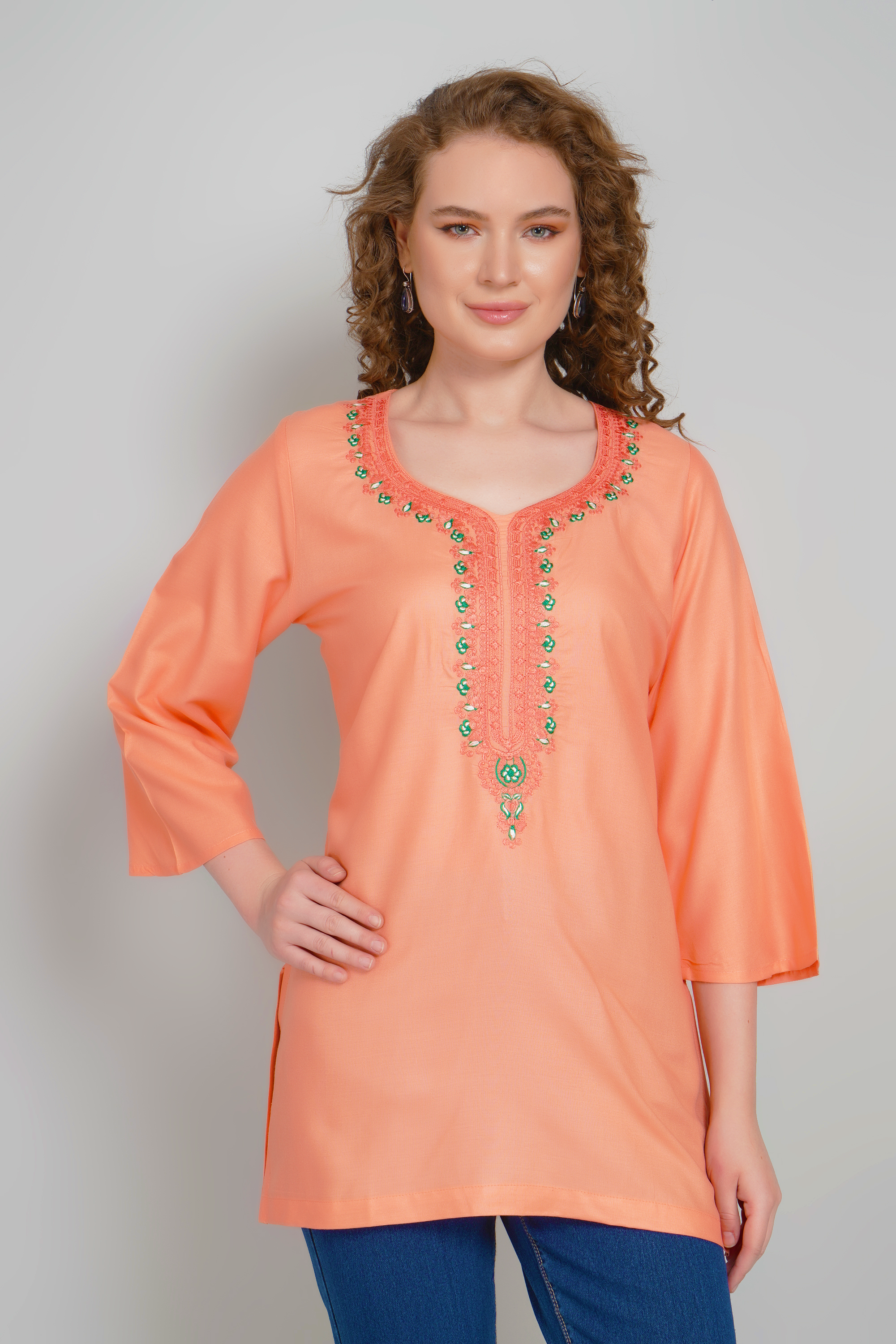 Women's peach-orange short kurti with colorful embroidered neckline, three-quarter sleeves
