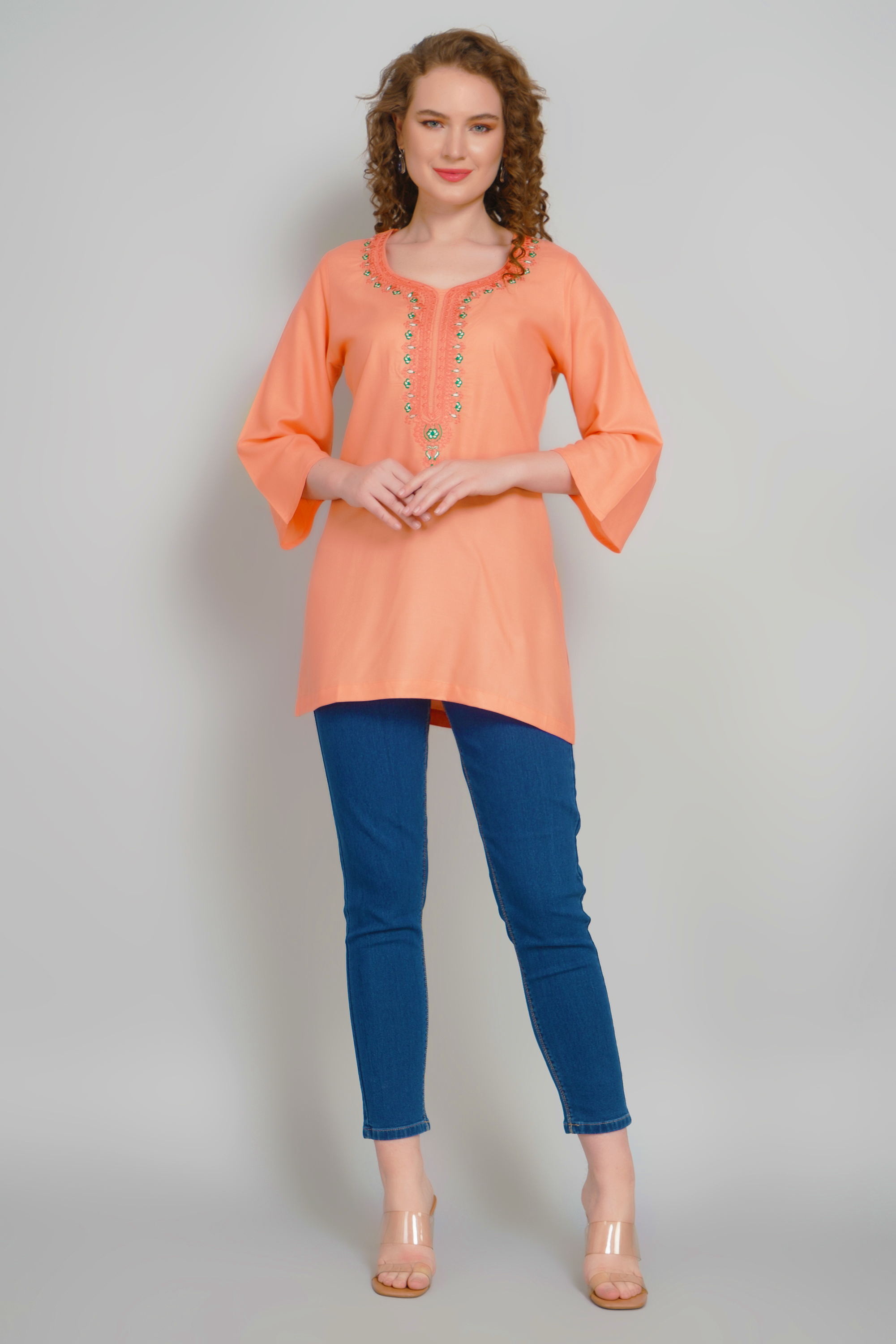 Women's peach-orange short kurti with embroidered round neckline and three-quarter sleeves
