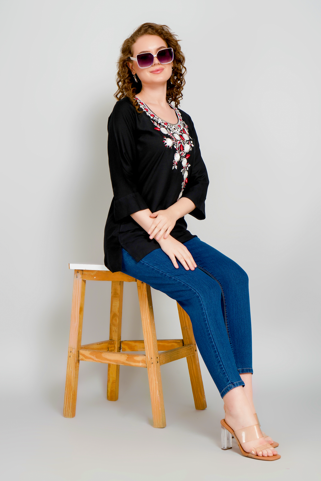 Women's black short kurta with floral embroidery at neckline, three-quarter sleeves
